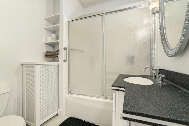 bathroom featuring toilet, enclosed tub / shower combo, and vanity