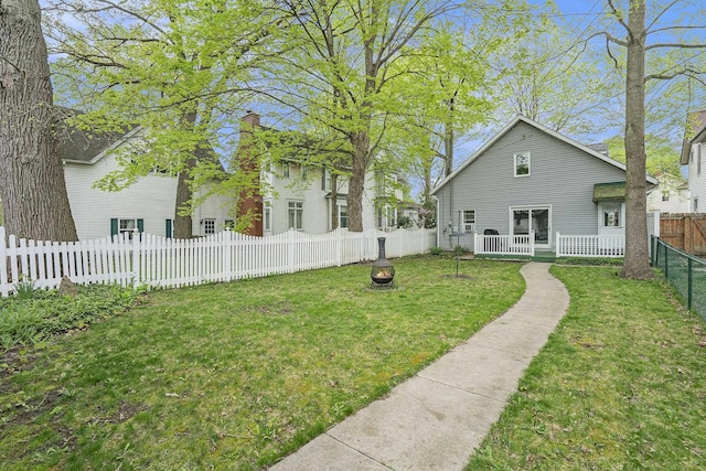 back of house with a fire pit and a chimney
