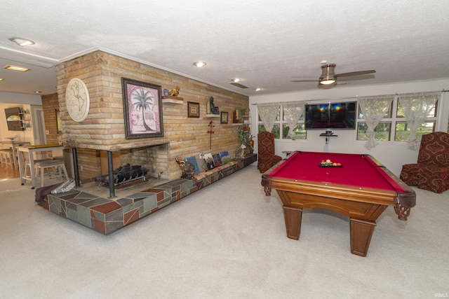 playroom with carpet floors, a textured ceiling, billiards, a ceiling fan, and a brick fireplace