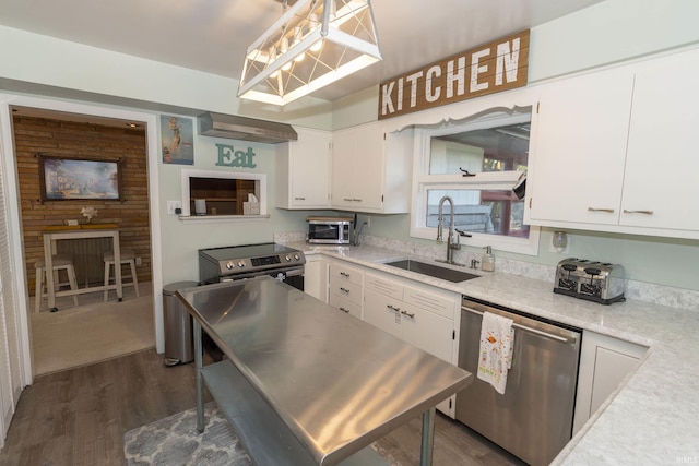kitchen featuring appliances with stainless steel finishes, a sink, light countertops, and white cabinetry
