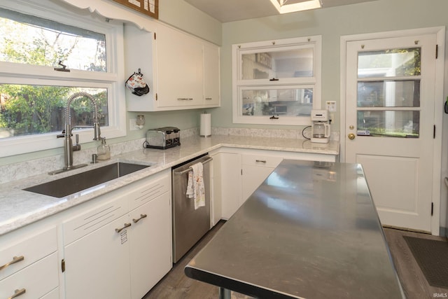 kitchen with a sink, stainless steel dishwasher, white cabinetry, and dark wood-style flooring