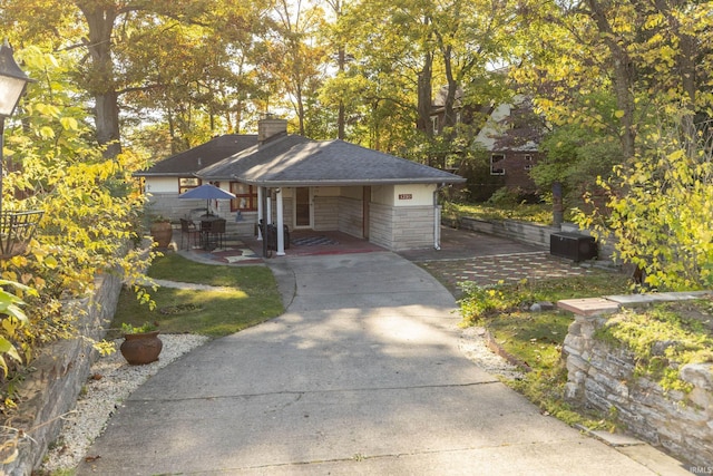 view of property's community featuring concrete driveway and a carport