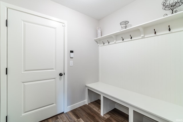 mudroom with dark wood-style floors and baseboards