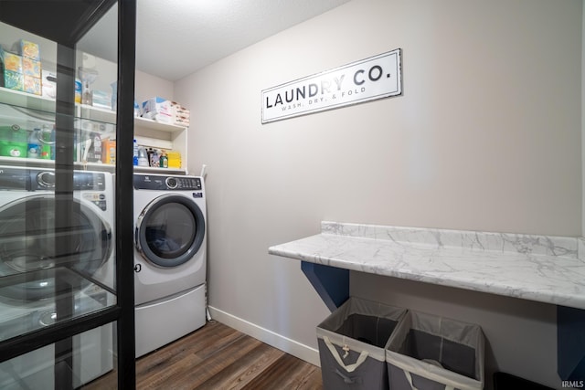 clothes washing area with washer and dryer, dark wood-style floors, and baseboards