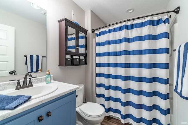 bathroom featuring vanity, a textured ceiling, toilet, a shower with shower curtain, and wood finished floors