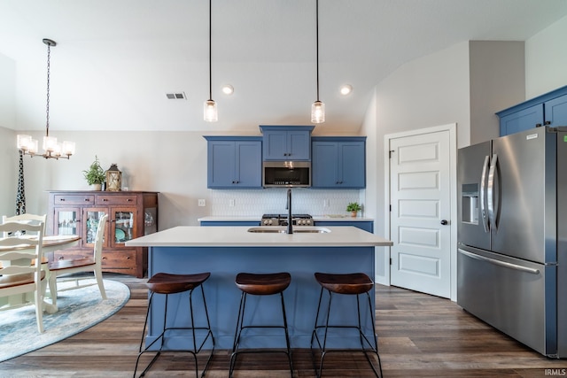 kitchen with stainless steel appliances, blue cabinetry, lofted ceiling, light countertops, and tasteful backsplash