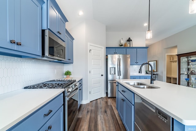 kitchen with appliances with stainless steel finishes, a sink, blue cabinetry, dark wood finished floors, and recessed lighting