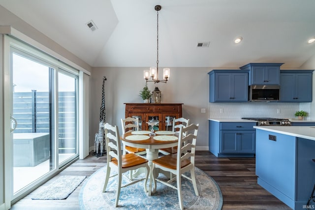 dining space with lofted ceiling, a chandelier, and dark wood-type flooring