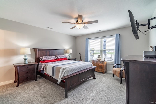 bedroom with light colored carpet, baseboards, and a ceiling fan