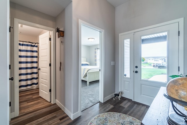 foyer with dark wood-type flooring and baseboards