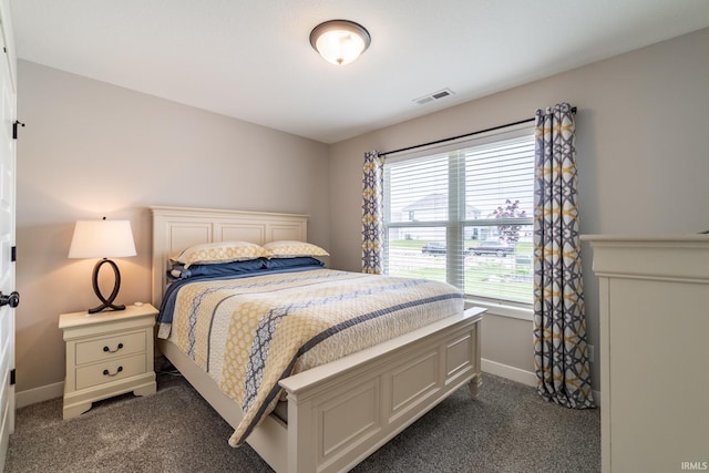 bedroom with dark carpet and baseboards