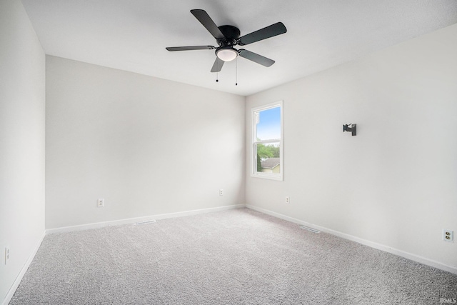 spare room with baseboards, light colored carpet, and ceiling fan