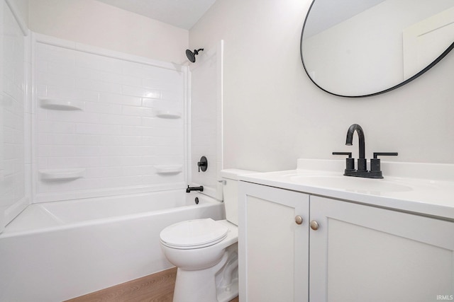 bathroom featuring toilet, vanity, wood finished floors, and shower / bathtub combination