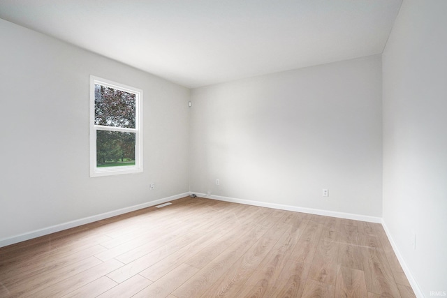 unfurnished room with light wood-type flooring and baseboards