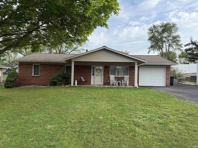 2823 Hillside Dr, Bedford, IN 47421 - ranch-style home featuring an attached garage, driveway, covered porch, a front lawn, and brick siding