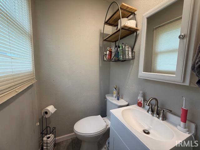 2823 Hillside Dr, Bedford, IN 47421 - bathroom featuring toilet, vanity, wood finished floors, and baseboards