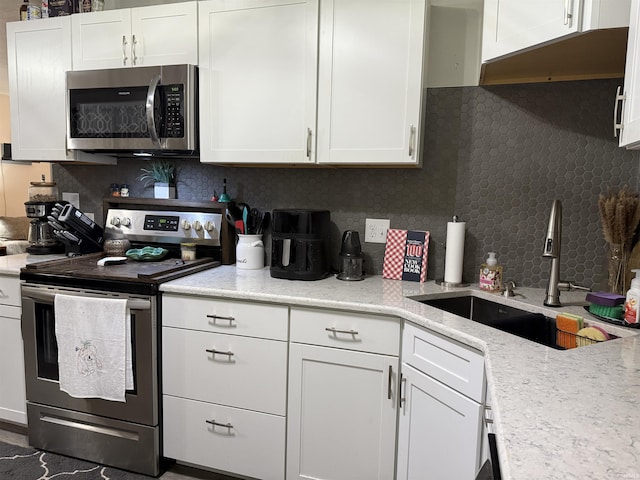 2823 Hillside Dr, Bedford, IN 47421 - kitchen featuring appliances with stainless steel finishes, a sink, white cabinetry, and decorative backsplash