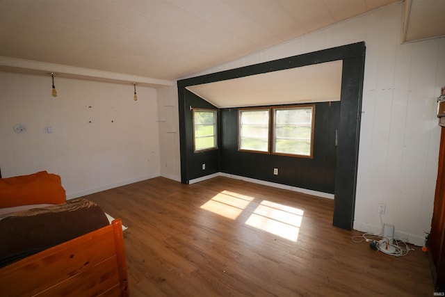 1008 W Elm St, Hartford City, IN 47348 - unfurnished living room with wood finished floors, vaulted ceiling, and baseboards
