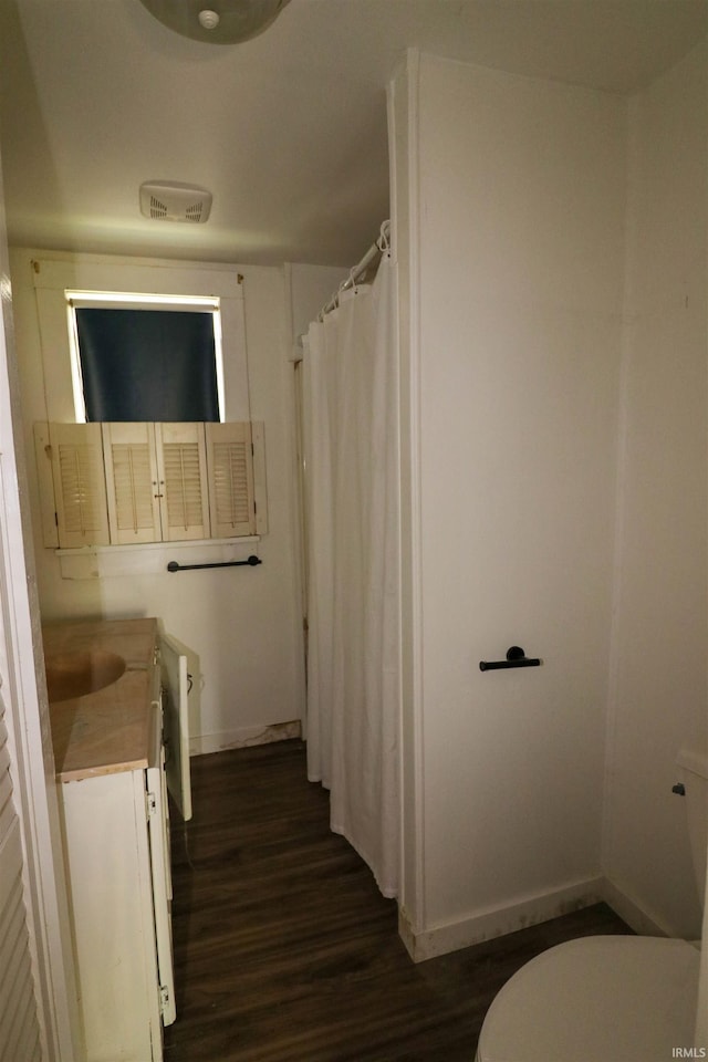 1008 W Elm St, Hartford City, IN 47348 - full bathroom with wood finished floors, baseboards, toilet, vanity, and a shower with shower curtain