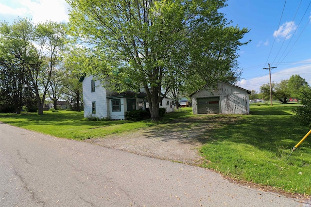 1008 W Elm St, Hartford City, IN 47348 - view of front of home featuring driveway, a garage, an outbuilding, and a front lawn