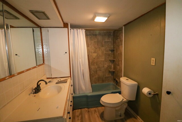 1008 W Elm St, Hartford City, IN 47348 - bathroom featuring toilet, wood finished floors, vanity, and shower / bathtub combination with curtain
