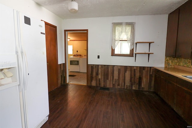 1008 W Elm St, Hartford City, IN 47348 - kitchen featuring washer and clothes dryer, dark wood-type flooring, white fridge with ice dispenser, a textured ceiling, and wainscoting