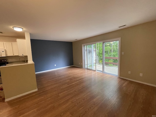 620 Bayberry Ct, Bloomington, IN 47401 - unfurnished living room featuring dark wood-style floors, baseboards, and a sink