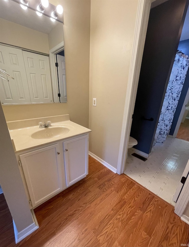 620 Bayberry Ct, Bloomington, IN 47401 - bathroom with wood finished floors, vanity, toilet, and baseboards