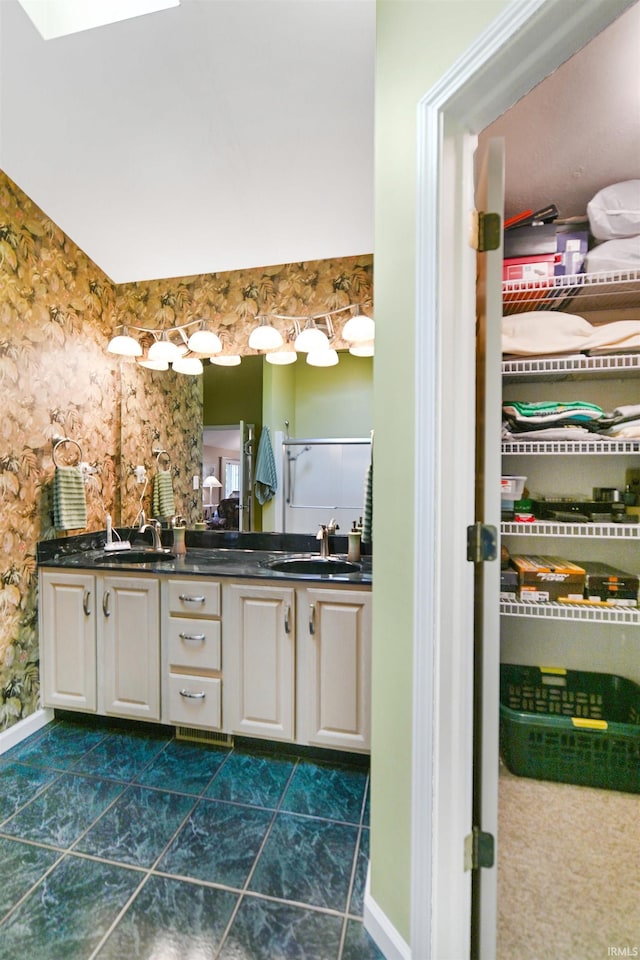 full bath with double vanity and baseboards