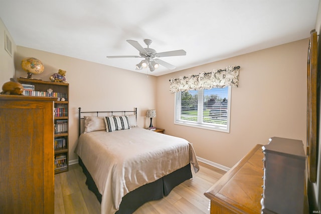 bedroom featuring wood finished floors, baseboards, and a ceiling fan