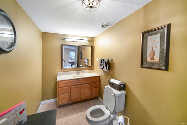 bathroom featuring baseboards, toilet, vanity, and a textured ceiling