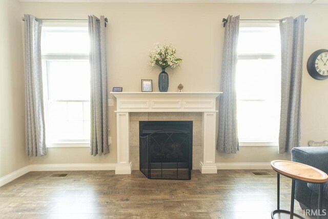 3417 S Tulip Ave, Bloomington, IN 47403 - living area featuring dark wood finished floors, a tiled fireplace, and baseboards