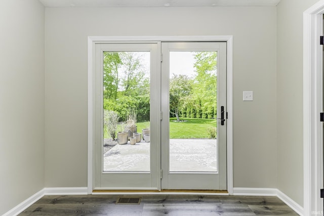doorway to outside with baseboards and dark wood-style flooring