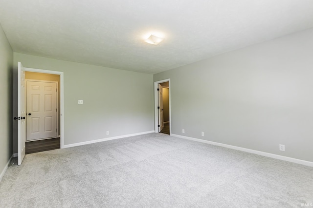 unfurnished room featuring carpet and baseboards