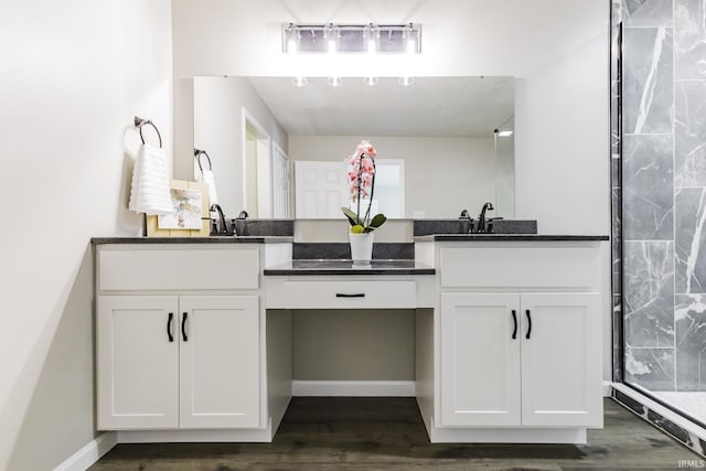 bathroom featuring vanity, wood finished floors, and a tile shower