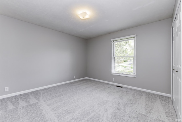spare room featuring carpet floors and baseboards