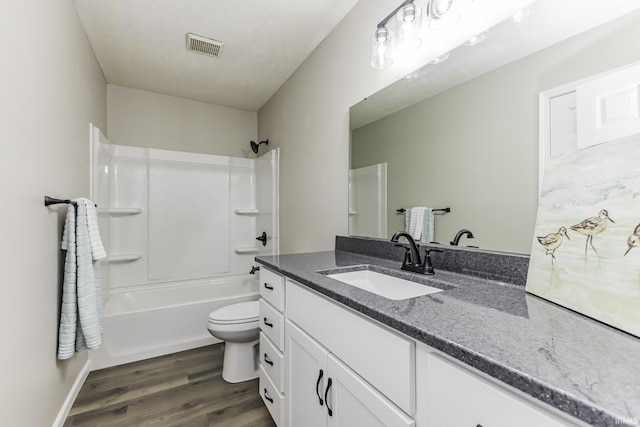 full bathroom featuring wood finished floors, vanity, toilet, washtub / shower combination, and baseboards