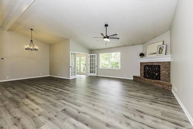 unfurnished living room featuring lofted ceiling, a ceiling fan, a fireplace, baseboards, and wood finished floors