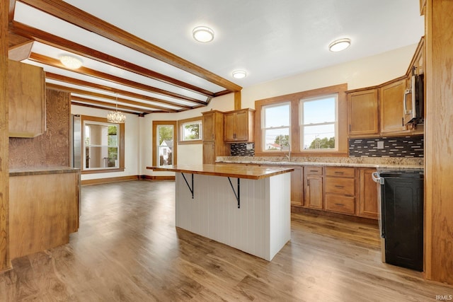 3910 E Bellefontaine Rd, Hamilton, IN 46742 - kitchen with stainless steel microwave, range with electric cooktop, tasteful backsplash, beamed ceiling, and light countertops