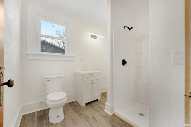 3910 E Bellefontaine Rd, Hamilton, IN 46742 - bathroom featuring wood finished floors, a stall shower, toilet, vanity, and baseboards