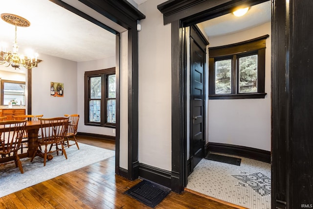 1026 N Michigan St, South Bend, IN 46617 - corridor featuring a chandelier, dark wood-style flooring, healthy amount of natural light, and baseboards