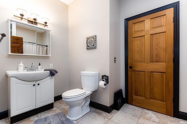1026 N Michigan St, South Bend, IN 46617 - bathroom featuring baseboards, toilet, and vanity