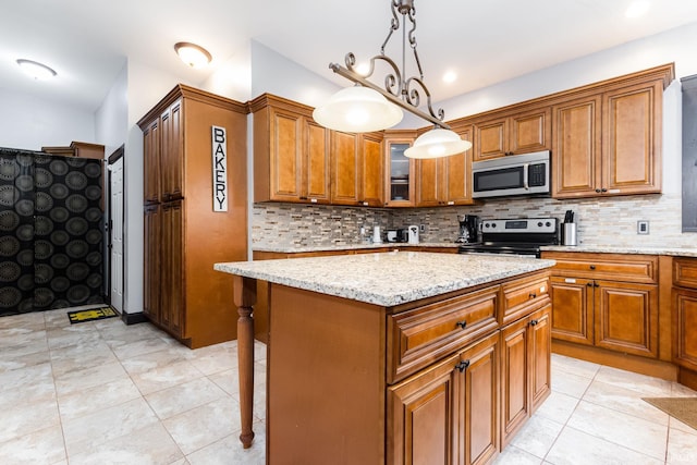 1026 N Michigan St, South Bend, IN 46617 - kitchen with stainless steel appliances, brown cabinetry, backsplash, light stone counters, and a kitchen island