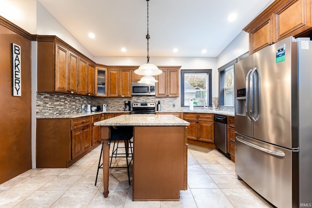 1026 N Michigan St, South Bend, IN 46617 - kitchen featuring stainless steel appliances, brown cabinetry, tasteful backsplash, a center island, and recessed lighting
