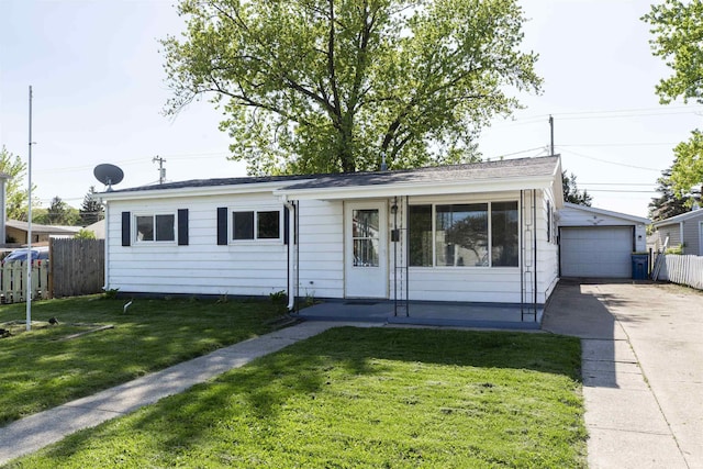 ranch-style home featuring concrete driveway, a detached garage, and an outbuilding