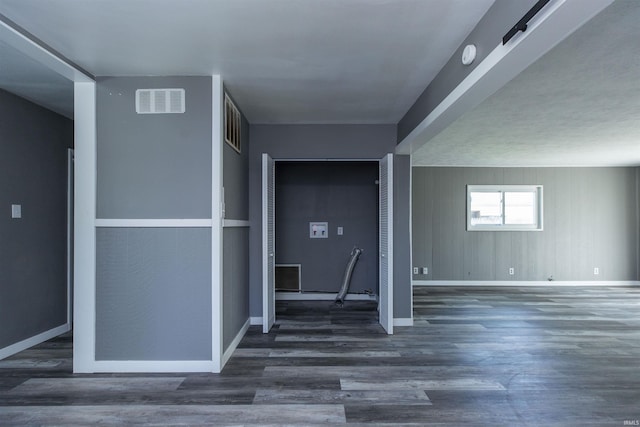 hallway featuring wood finished floors and baseboards