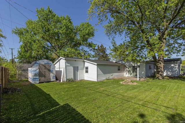 view of yard featuring a storage unit, an outbuilding, and a garage