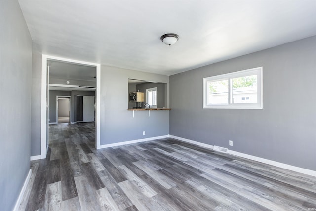 unfurnished room with dark wood-style flooring and baseboards