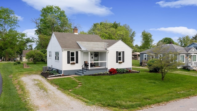 bungalow featuring a porch, a chimney, driveway, a front lawn, and roof with shingles