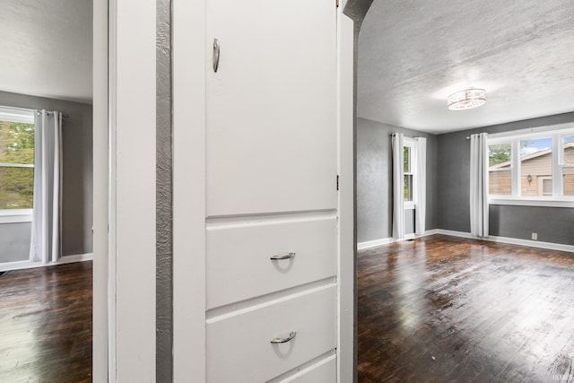 interior space with wood finished floors, baseboards, and a textured ceiling